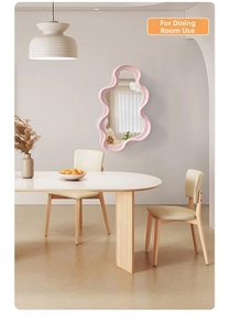 Pink wavy border irregular mirror displayed as decorative wall decor in a dining room