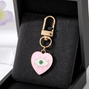 Pink heart-shaped evil eye keychain with gold-plated lobster clasp on velvet pad