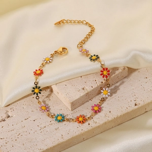 Vista detallada de la pulsera de titanio de 18K con dijes de margaritas de esmalte de colores