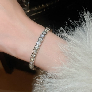 Detailed view of silver luxury heart link bracelet with sparkling cubic zirconia on wrist