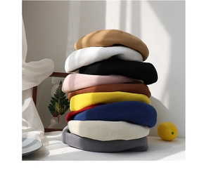 Vertical stack of colorful knitted berets showing various candy colors and soft textures
