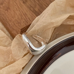 Minimalist S925 sterling silver ring with irregular wavy design on a wooden tray