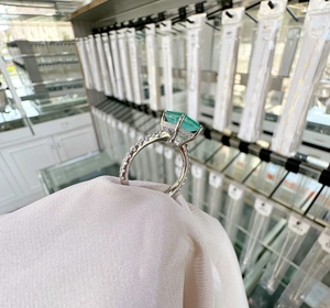Side view detail of 8x10mm emerald cut green stone set in sterling silver ring
