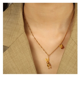 Close-up of mechanical bunny pendant and square tag on golden titanium steel chain