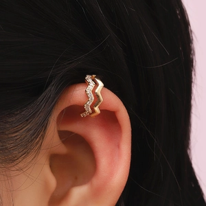 Close-up of elegant double-layered gold ear cuff with small inlaid zircons on a model