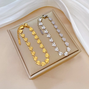 Minimalist heart chain bracelets in gold and silver stainless steel on jewelry box