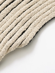 Macro detail showing the ribbed knit texture and soft beige cotton fabric of the lounge set
