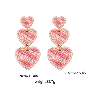Detailed size chart showing pink beaded heart drop earrings with dimensions and weight