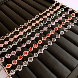 Gros plan des colliers à fleurs vintage avec cristaux multicolores sur un plateau noir