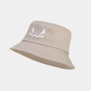 Detail of khaki bucket hat showing white monster face embroidery and stitched brim finish