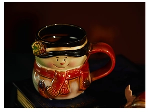Detailed view of 3D snowman ceramic Christmas mug with red scarf and black hat lid
