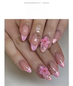 Macro shot of 3D pink flowers and pearls on pearlescent almond press-on nails