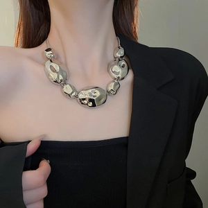 Detail of silver irregular molten metal bead necklace with crinkled texture on model