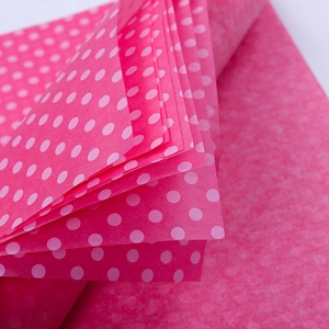 Stack of pink polka dot tissue paper sheets for gift wrapping and floral packaging