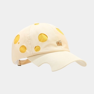 Detail of cheese-themed baseball cap featuring yellow hollow cut-outs and 3D embroidery