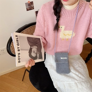 Detailed view of gray faux fur crossbody phone bag paired with a pink duck sweater