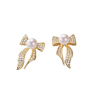 Elegant golden bow earrings featuring a white freshwater pearl and shimmering cubic zirconia