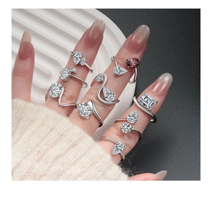 Detail of silver rings with various white zircons and purple gemstone on model hand