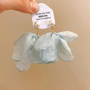 Detailed macro view of S925 silver stud earrings featuring soft light blue mesh fabric petals