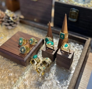 Detailansicht von Vintage Malachit und Türkis Ringen auf hochwertigen Holzdisplay-Ständern