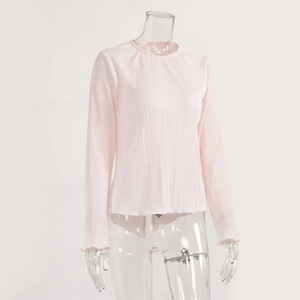 Detail of light pink pleated fabric with textured vertical ruffles and bell sleeve cuff