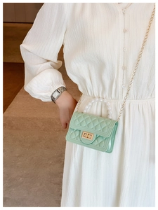Detailed view of light green jelly mini bag with pearl handle and golden chain strap