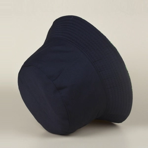 Détail du tissu bleu marine et de l'imprimé vert tropical réversible du chapeau cloche