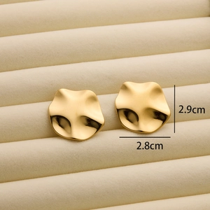 Close-up of golden irregular wavy stud earrings with dimensions of 2.9cm by 2.8cm