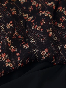 Detailed macro view of black paisley and floral print on soft chiffon dress fabric