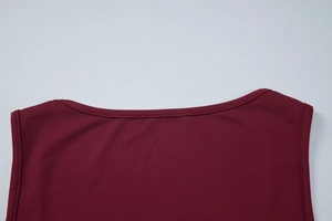 Dettaglio del top in maglia bordeaux che mostra il bordo in pizzo e la doppia cucitura