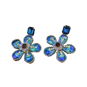 Boucles d'oreilles vintage fleurs en cristaux bleus et strass sur fond blanc