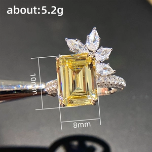 Luxurious yellow emerald-cut zircon ring with crown-shaped diamond accents and a halo