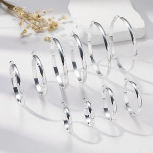 Polished S925 sterling silver hoop earrings in various sizes on a minimalist display