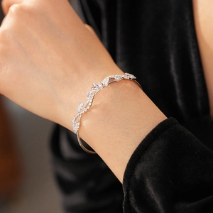 Nahaufnahme des Blumenranken-Armbands mit Zirkonia-Steinen am Handgelenk eines Models