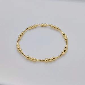 Dettaglio del bracciale elastico a perline placcato oro 18K con lucentezza metallica