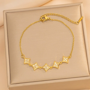 Elegantes Goldarmband mit fünf diamantbesetzten Sternanhängern auf einer Schmuckbox