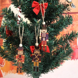 Close-up of wooden nutcracker soldier ornaments with twine on a green Christmas tree