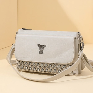 Elegant beige crossbody bag with metal rabbit ornament and studded rhinestone details