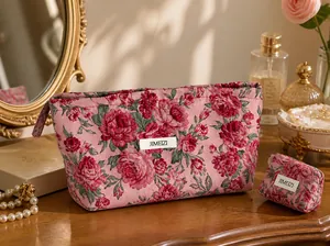 Dettaglio ricamo rose rosse su una borsa da viaggio vintage rosa per cosmetici e trucco