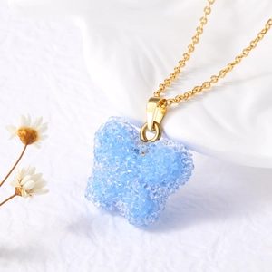 Détail macro d'un pendentif papillon bleu clair sur une chaîne dorée élégante