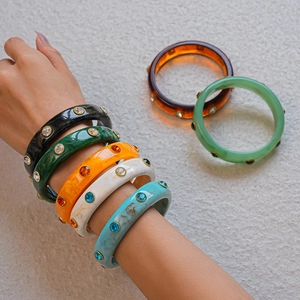 Detailed close-up of acrylic colorful resin bangles with inlaid sparkling crystals