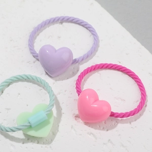 Élastiques à cheveux cœur macaron en rose, violet et vert menthe sur fond texturé