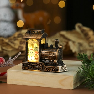 Close-up of vintage bronze Christmas train lantern with snowman scene and warm LED light