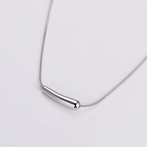 Detailed view of polished silver snake chain necklace with curved metal bar pendant