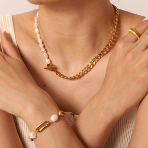Détail du collier chaîne cubaine dorée et perles avec fermoir en T sur mannequin