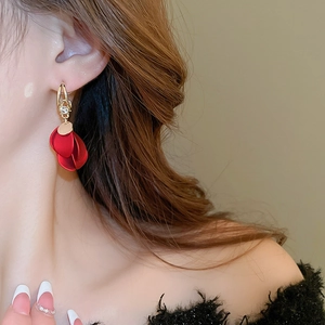 Close-up of red matte petal tassel earrings with sparkling rhinestones on a female model