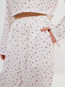 Détail du tissu à œillets fleuri rose avec imprimé Teneri et poche latérale du pyjama