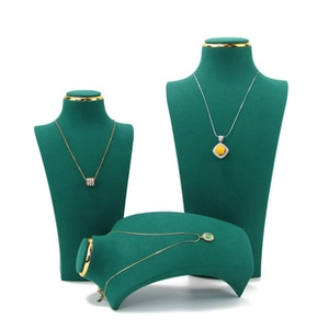 Dark green velvet necklace display stand set with gold metal accents on white background