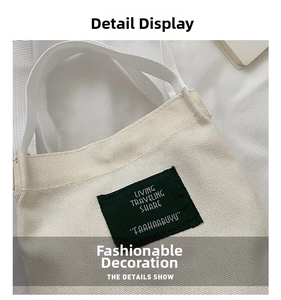 Close-up of minimalist cream canvas bucket bag featuring a green square woven logo patch