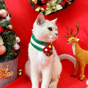 Detail view of a knitted green pet Christmas scarf with a 3D tree on a white cat